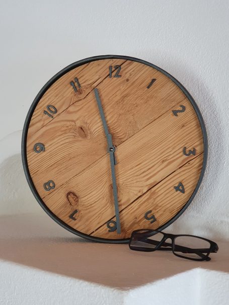 Wanduhr Antikholz und Stahl Holzwanduhr mit römischen Ziffern und einer Brille daneben.