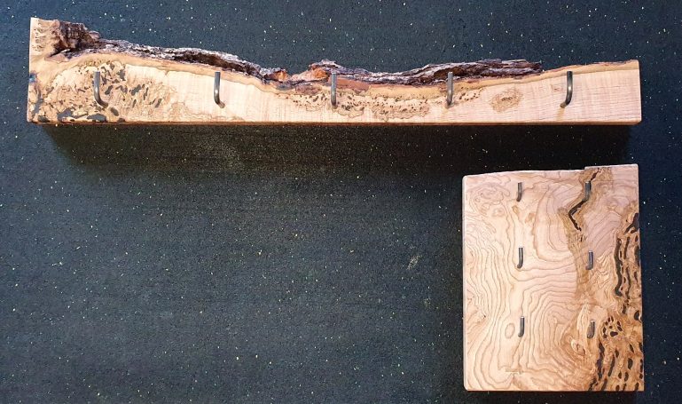 Garderobe und Schlüsselbrett Esche Holzstücke mit unregelmäßigen Kanten und eingelassenen Haken.